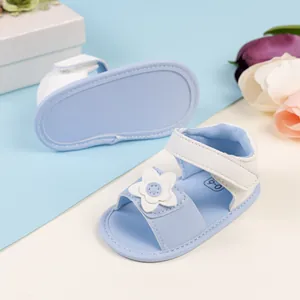 Dettaglio di sandali azzurri per neonati con fiore 3D bianco e chiusura con velcro