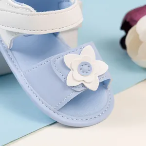 Dettaglio dei sandali blu per neonata con ornamento floreale bianco a doppio strato decorativo