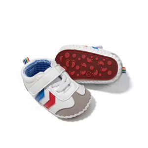 Detail of baby walking shoes with non-slip red rubber sole and stylish velcro straps