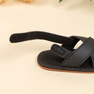 Detailed close-up of baby boy sandals featuring black synthetic leather and velcro strap