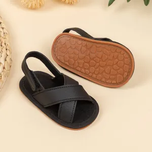Detail of baby summer sandals featuring black faux leather and anti-slip rubber soles
