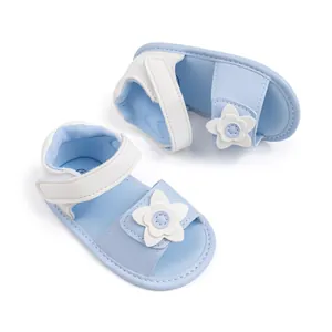 Dettaglio sandali per neonata con fiori bianchi applicati e cinturino in velcro