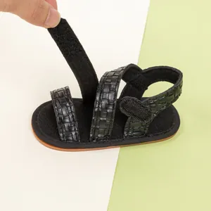 Detail showing the adjustable hook and loop closure on these black woven baby sandals