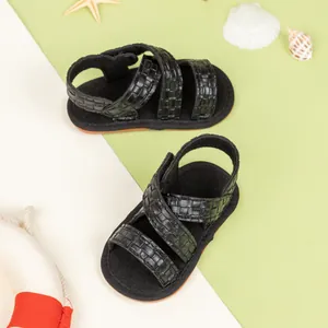 Detail of black faux leather baby sandals featuring woven texture and non-slip soft sole