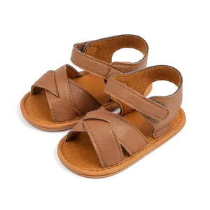 Detailed view of brown baby sandals with textured leather straps and Velcro ankle closure