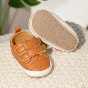 Detailed macro view of brown baby walking shoes with non-slip sole and hook-and-loop straps