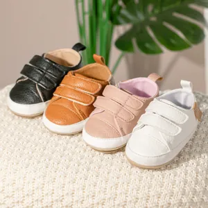 Detailed view of non-slip baby walking shoes in black, brown, pink and white leather