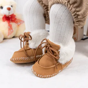 Detailed view of warm brown baby boots with white faux fur lining and lace-up design