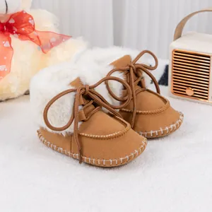 Detailed close-up of brown baby winter boots with warm plush lining and lace-up design