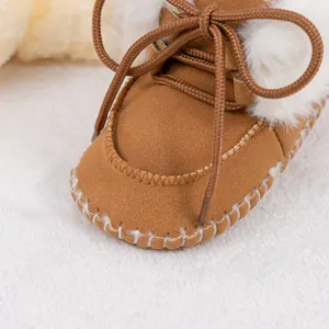 Brown soft sole baby snow boots with white faux fur trim and bow tie detail