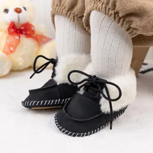 Detail shot of black suede baby boots with faux fur collar and white hand-stitched sole
