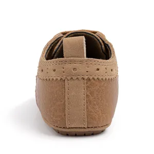 Λεπτομέρεια καφέ βρεφικά παπούτσια Oxford με brogue σχέδια και μαλακή αντιολισθητική σόλα