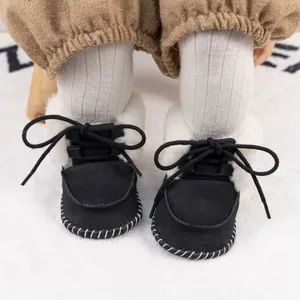 Detail of warm black baby winter boots with faux lamb wool lining and lace-up design
