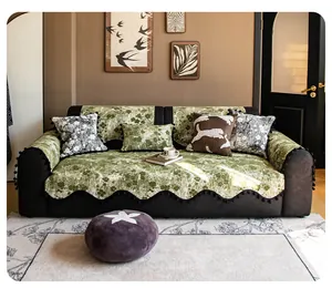 Detail of green floral chenille sofa cover with pom-pom fringe and woven texture