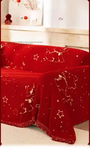 Detail of red cartoon sofa cover featuring gold jacquard stars and elegant tassel fringe
