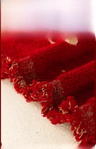 Macro detail of red houndstooth jacquard fabric with elegant tassel trim for sofa covers