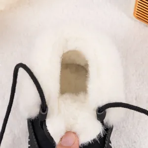 Close-up of thick white plush fleece lining inside a warm black winter baby boot