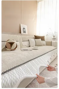 Detail of beige chenille sofa cover with wavy edges and ribbed plush texture