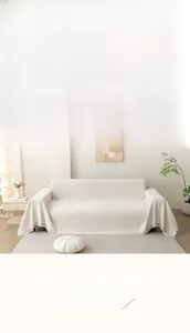 Detailierte Textur des cremeweißen Chenille-Sofaüberwurfs mit Fransen im Wohnzimmer