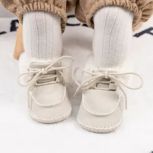 Detail of warm beige baby bootie with thick plush lining and rustic hand-stitched sole