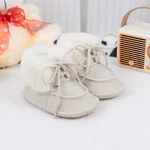 Detailed close-up of beige baby winter boots with soft faux fur lining and lace-up design