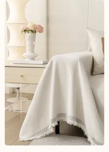 Detail of chenille sofa cover showing diamond jacquard texture and tassel fringe edge