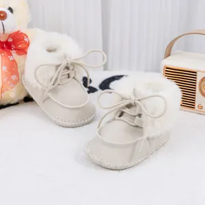 Detailed view of cream baby snow boots with plush faux fur lining and lace-up design