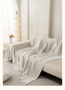 Detail of cream chenille sofa cover showing diamond weave texture and elegant fringe tassels