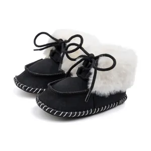 Detail view showing the design and texture of black suede baby boots with white faux fur lining.
