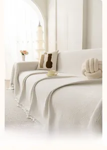 Detail of cream chenille sofa cover with diamond weave texture and white fringes