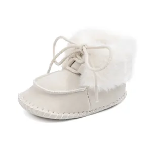 Detail of baby winter boot featuring cream faux suede fabric and white faux fur collar trim