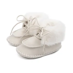Detail of warm baby winter boots in cream with faux fur lining and lace-up closure