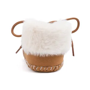 Detailed macro of baby winter boots with camel suede, plush faux fur trim and hand-stitched soles