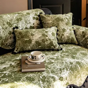 Dark green chenille sofa cover and pom-pom pillows with snow texture in cozy living room