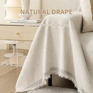Beige chenille sofa cover with geometric diamond pattern and fringe edge detail