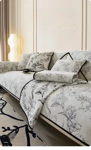 Détail du tapis de canapé en chenille crème avec motif floral gris et bordure