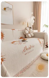 Détail de housse de canapé en chenille avec motifs de Noël et bords à franges