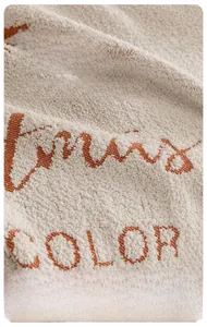 Gros plan du tissu chenille épais crème pour canapé avec broderie orange détaillée