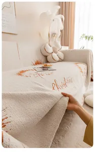 Détail de la housse de canapé épaisse en chenille avec flocons orange et bords frangés