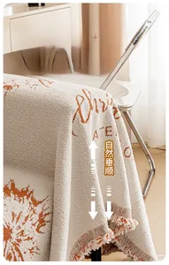 Détail d'un jeté de canapé en chenille avec motifs de Noël et bordures à franges