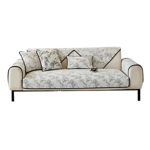 Housse de canapé en chenille beige avec fleurs noires et coussins sur fond blanc éclatant