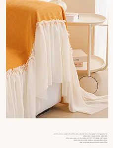 Détail de la housse de canapé en tricot jaune avec bordure élégante en dentelle de mousseline