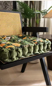 Dik bloemig brokaat stoelkussen met groene fluwelen zijkanten op klassieke rotan stoel
