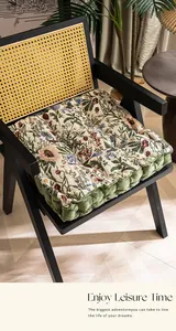 Detailopname van een bloemenprint stoelkussen met olijfgroene bies en wattering