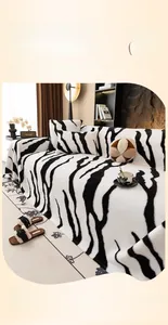 Detail of plush zebra stripe sofa cover with soft faux rabbit fur texture and matching pillows