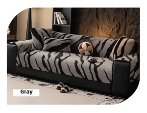 Detail of plush zebra stripe sofa cover with soft cushions on a black leather couch