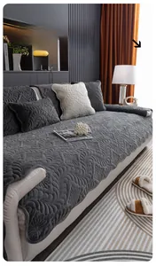 Close-up of dark grey plush sofa cover with quilted floral pattern and matching pillows