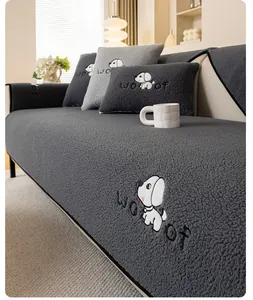 Detail of gray plush sofa cover featuring white cartoon dog embroidery and soft wool texture