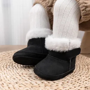 Gros plan sur des bottes d'hiver bébé en daim noir avec bordure épaisse en fausse fourrure