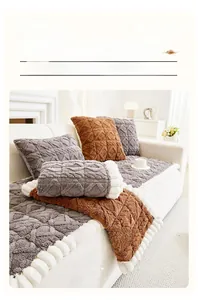 Detail of plush grey sofa cushion with diamond embossed pattern and white wavy trim